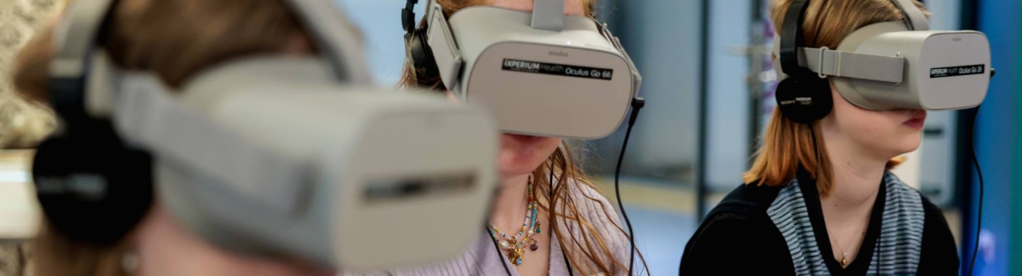 Drie vrouwen met een grijze virtual reality bril op 