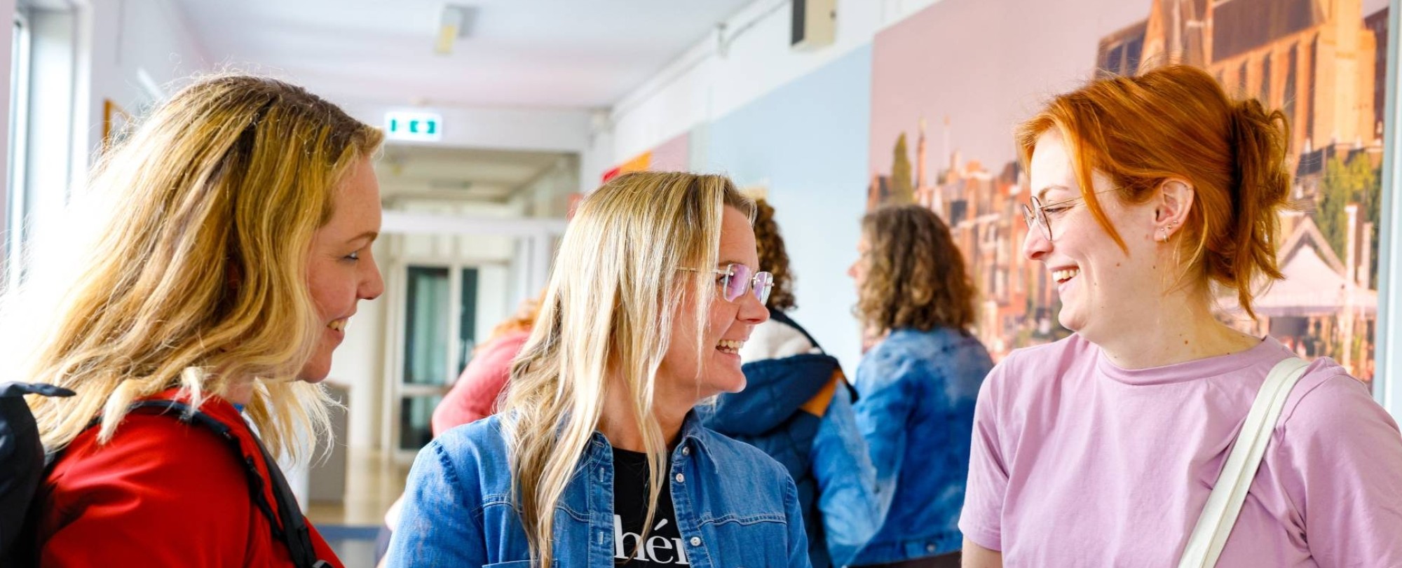 Vijf studenten die aan het overleggen zijn aan een houten tafel