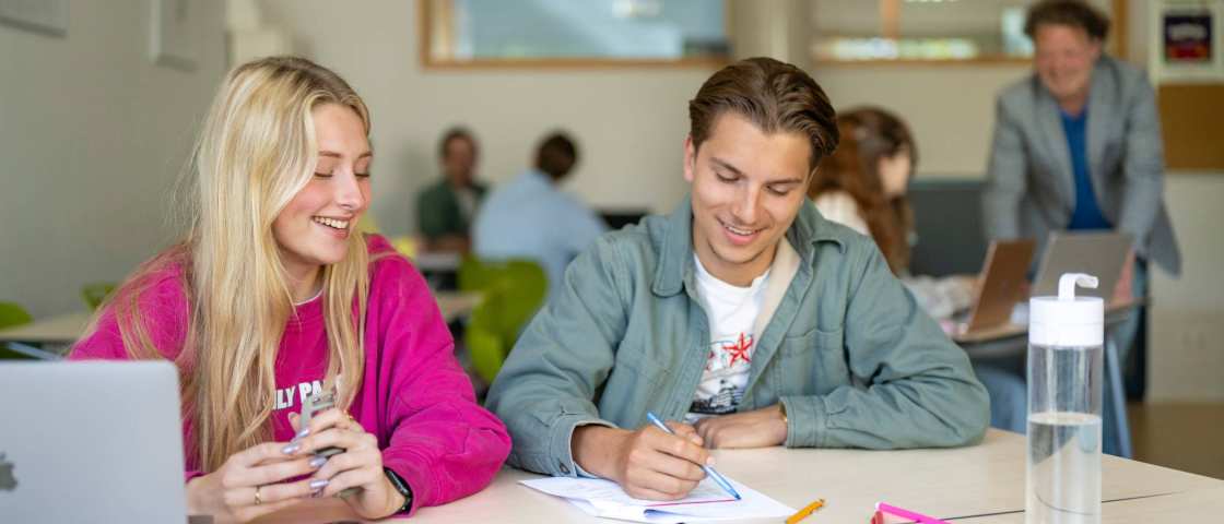 Twee studenten werken samen en hebben plezier. 