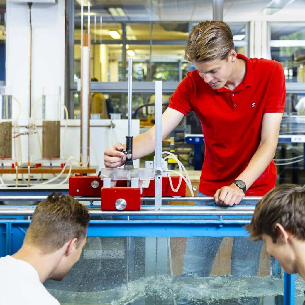 drie studenten simuleren in het waterlab situaties voor civiele techniek waterbouwkunde 