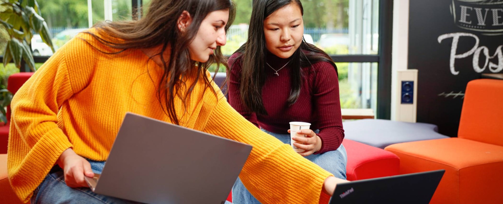 Twee studenten met laptop overleggen en wijst naar scherm