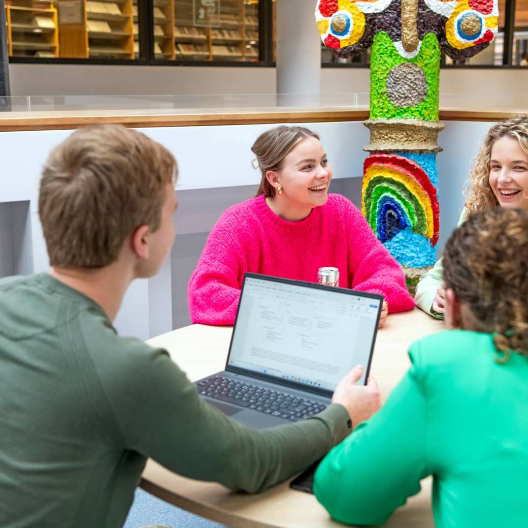 Studenten zitten gezellig samen en lachen.