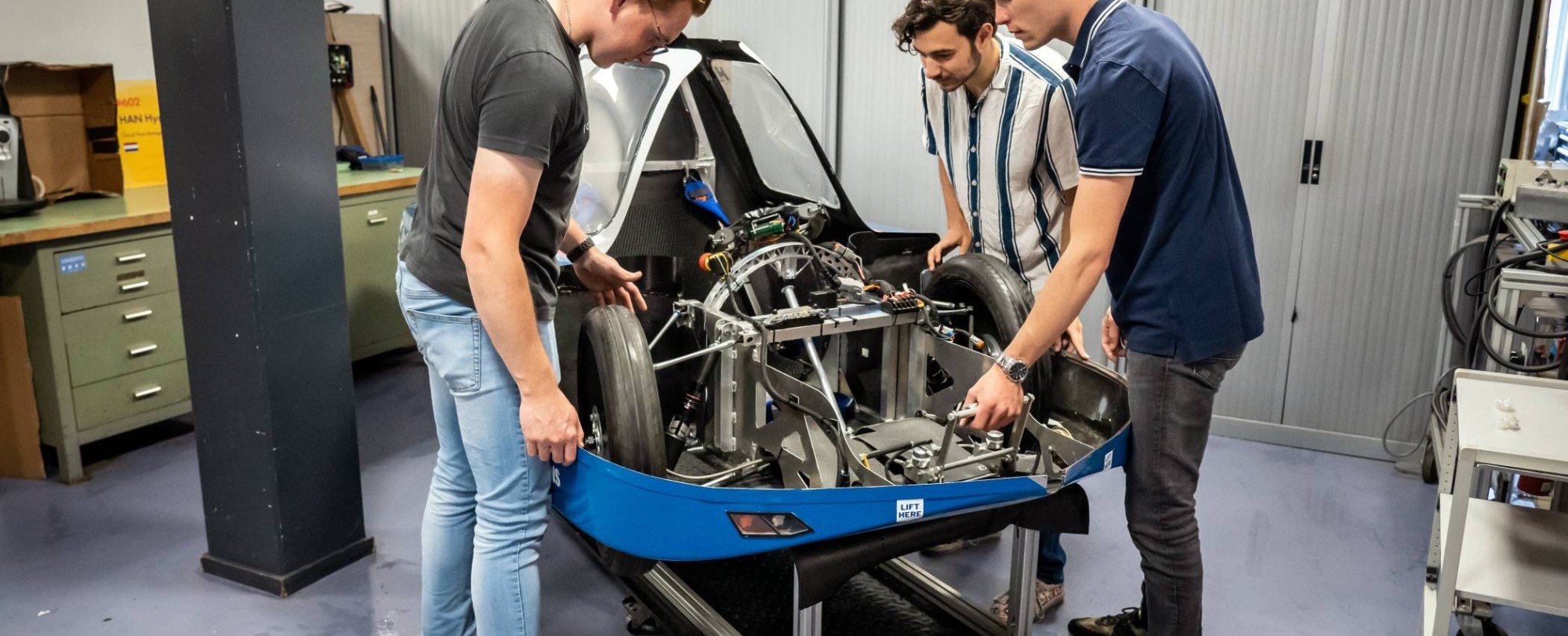 Drie studenten automotive werken samen aan het MH15 voertuig van de HAN.
