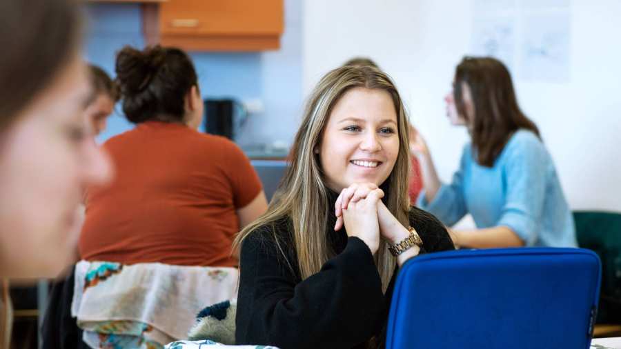 student ergotherapie zit achter laptop en is in gesprek