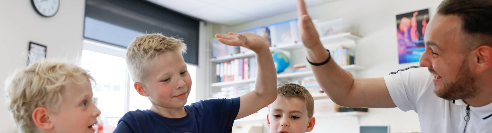 Kinderen met meester achter Ipad