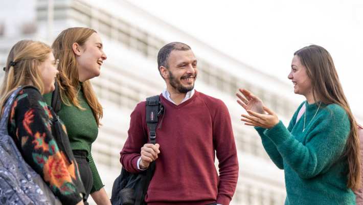 4 studenten praten buiten met elkaar.