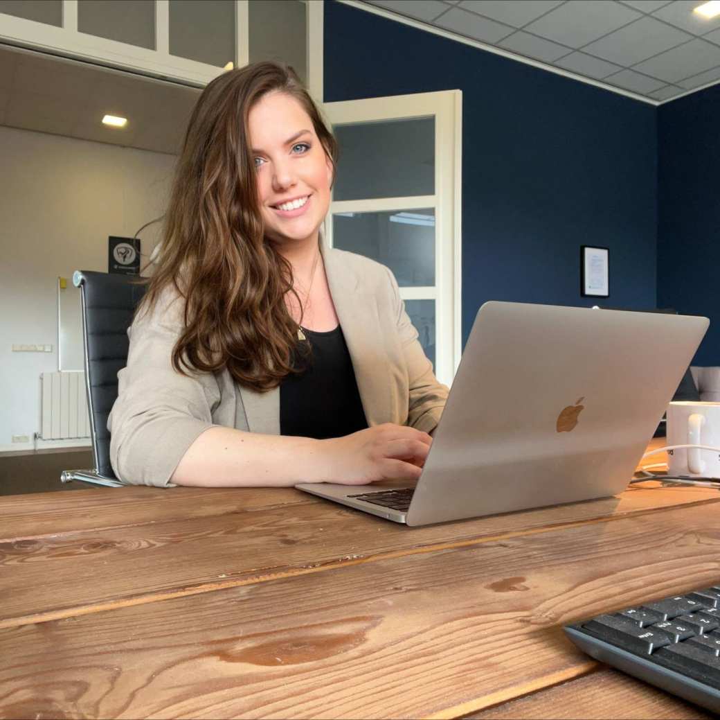 CMD alumnus Sharon Peters zit aan tafel achter haar laptop