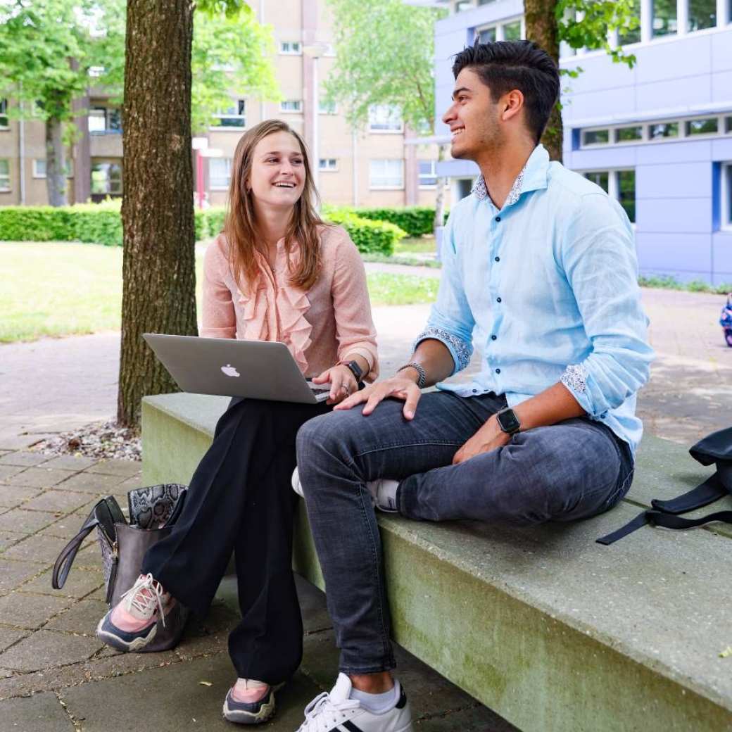 twee studenten van bedrijfskunde buiten bij de HAN campus