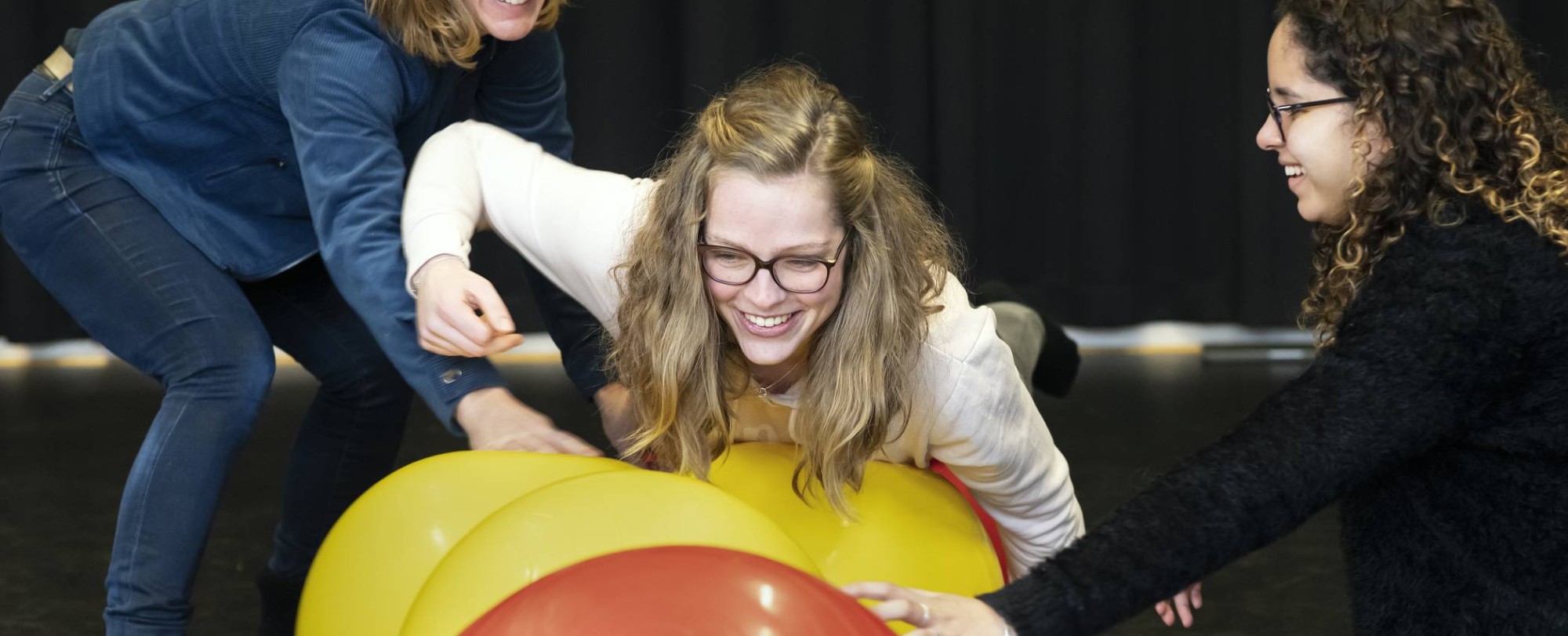 3 studenten van de han master vaktherapie psychomotorische therapie doen een oefening met skippyballen in de gymzaal