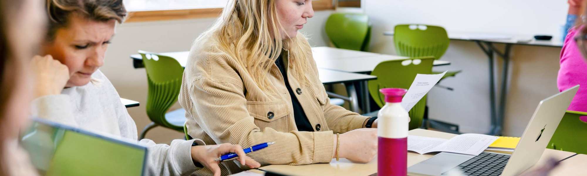 Student leest een blaadje. 