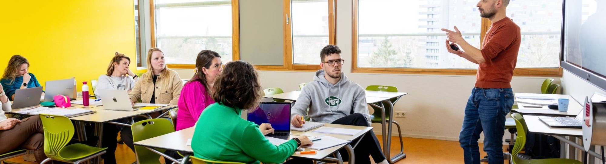 De studenten kijken naar de leraar die hun les geeft in het klaslokaal. 