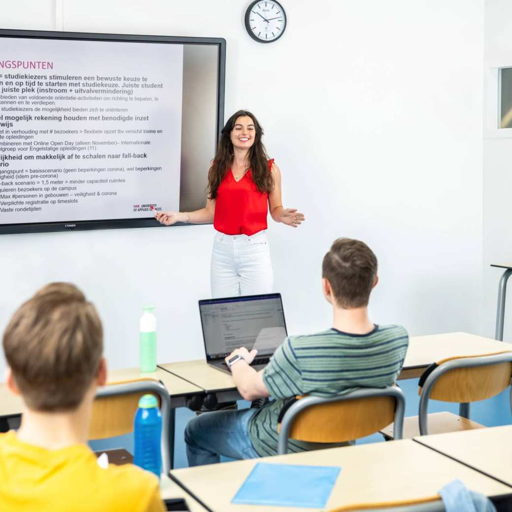 2 vrouwelijke studenten Social Work staan voor de klas en geven een presentatie. Je leert heel veel kennis en vaardigheden.