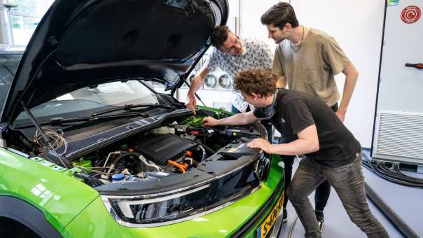 Automotive krijgen uitleg van een docent onder de motorkap van een moderne elektrische auto