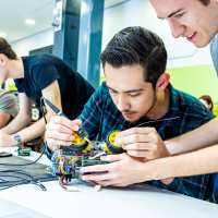 Studenten embedded systems engineering solderen aan programmeerbare auto.