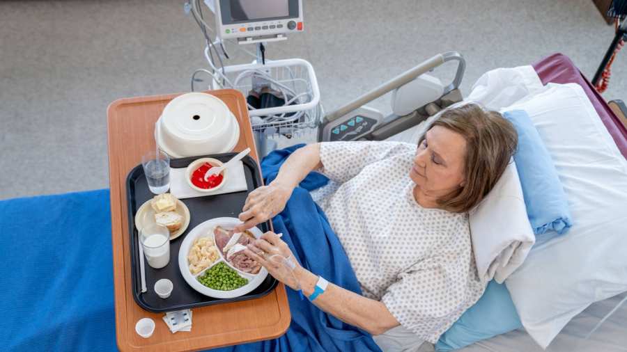 Patient met eten en drinken aan het bed in het ziekenhuis