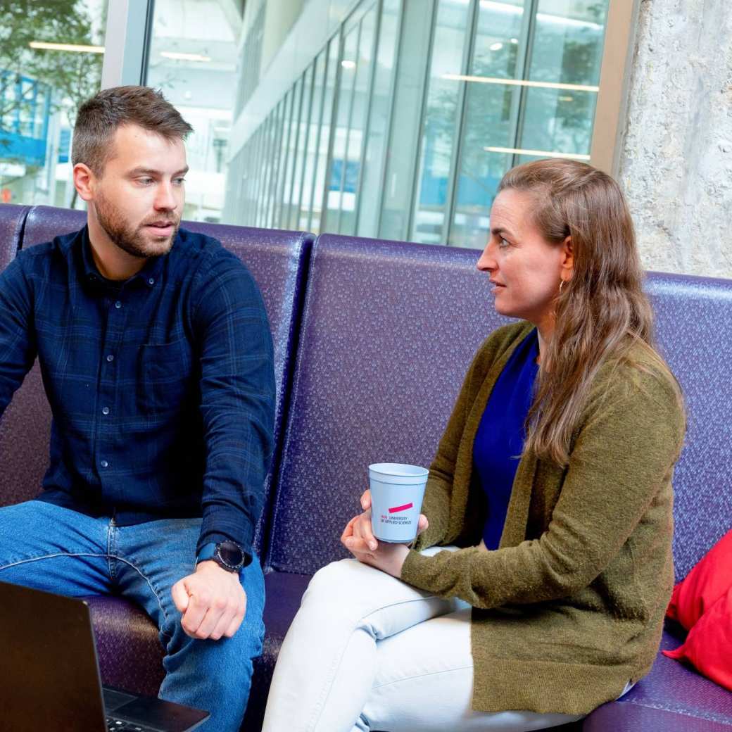 Twee studenten in gesprek met laptop op voorgrond. Master Circulaire Economie (DT) 2024.
