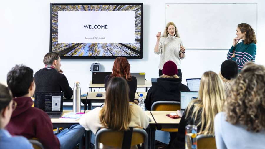 International Social Work. Klas college groep studenten en docent. digiboard op de achtergrond