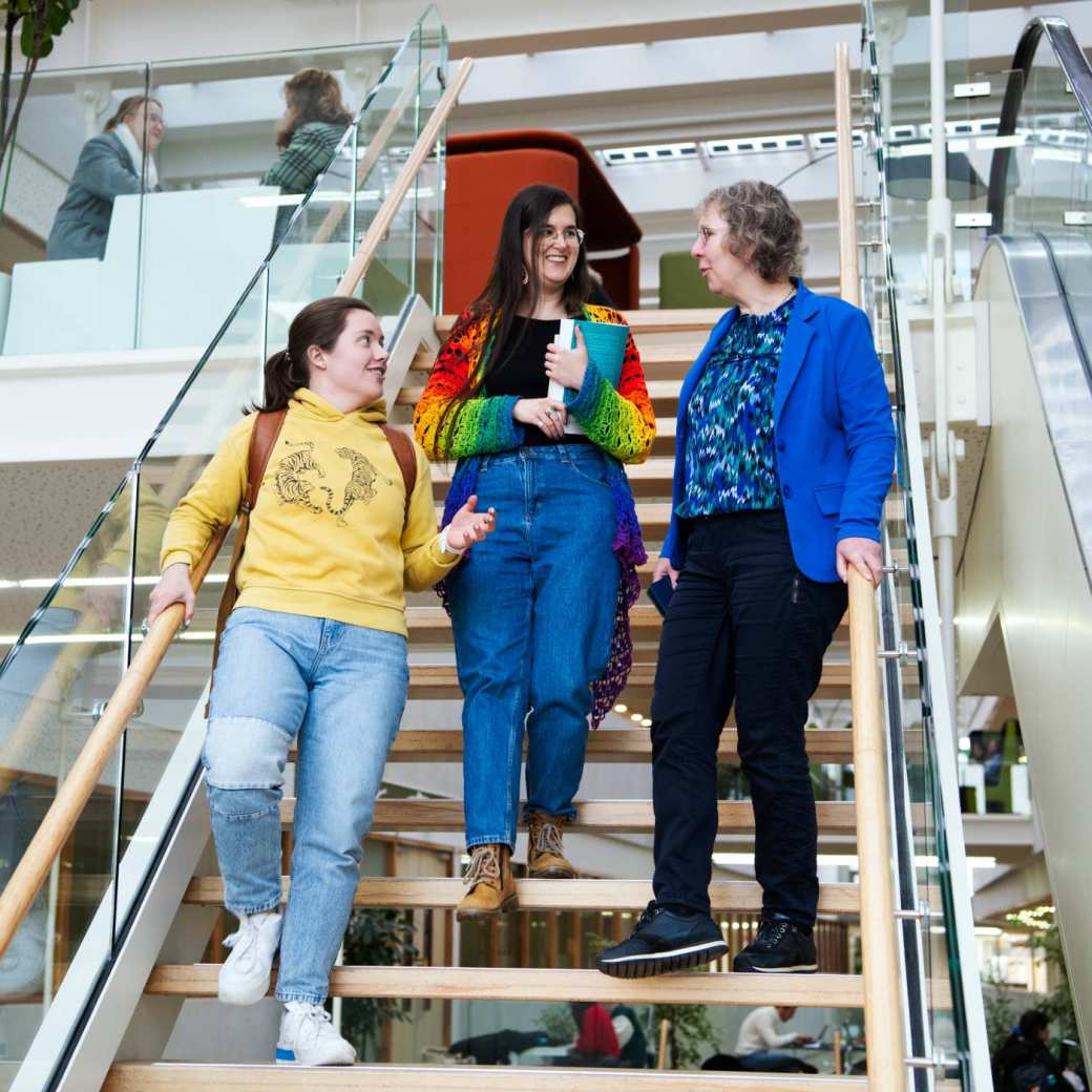 Foto Master Academie Educatie. 3 masterstudenten lopen de trap af terwijl ze praten op Kapittelweg 35, Nijmegen. 