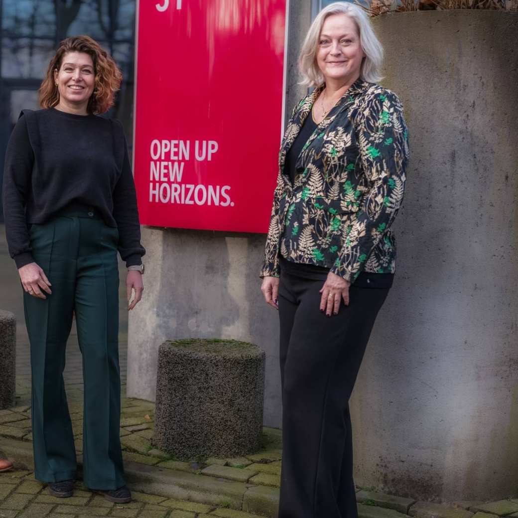 Fotomoment bij de hernieuwde samenwerking tussen de HAN en business School Nederland. Petra van Halteren van de HAN poseert met Linda Hoksbergen en Bart Stolk van BSN. Voor het HAN-gebouw op Ruitenberglaan 31