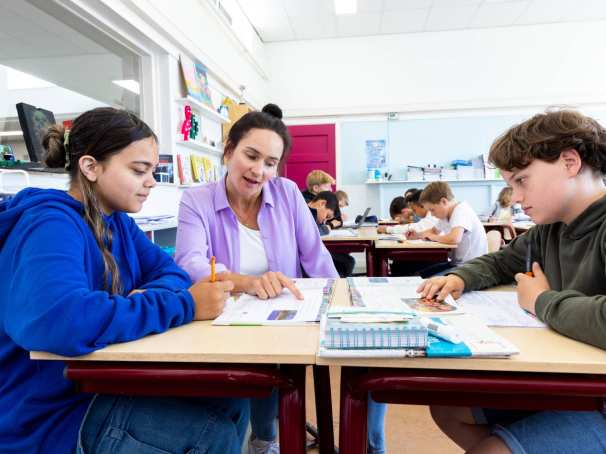 Docent Leonie van de opleiding leraar basisonderwijs aan tafel met leerlingen