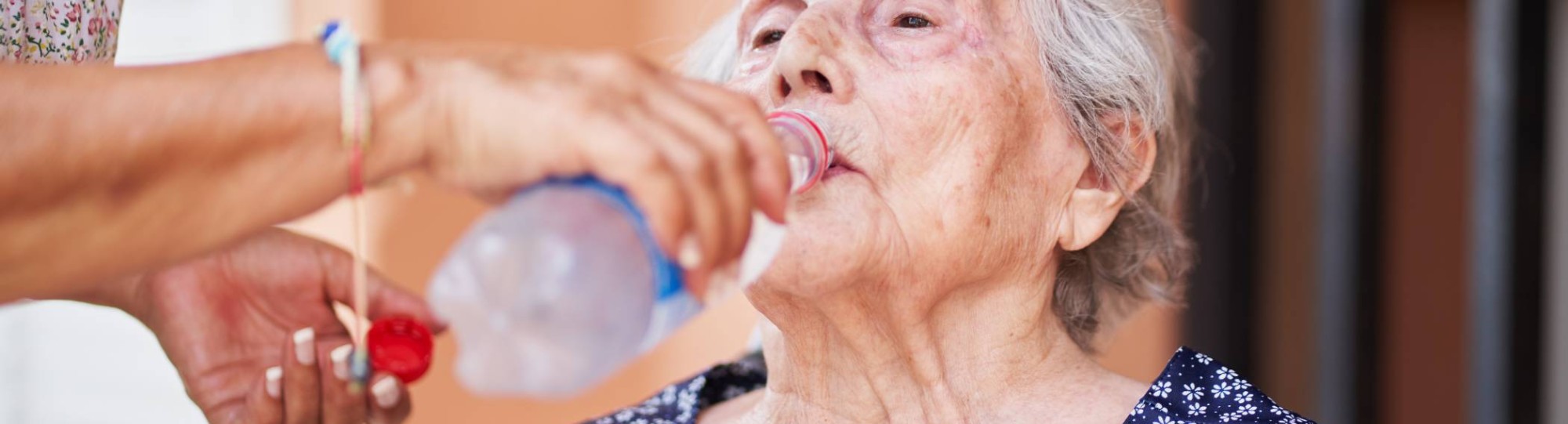 Oudere vrouw krijgt water toegediend