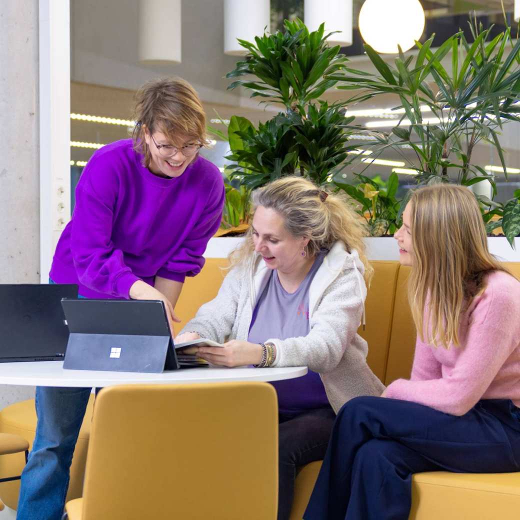 Student wijst iets aan op laptop aan andere studenten