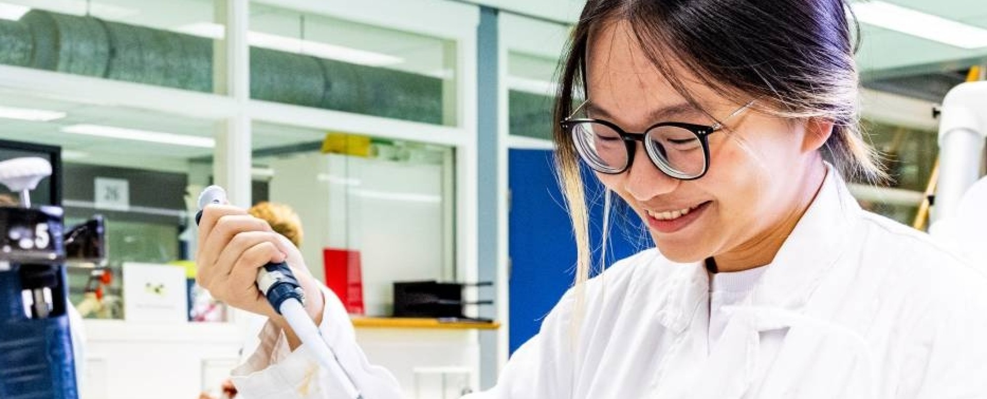 student aan de slag met een pipet in het chemielab