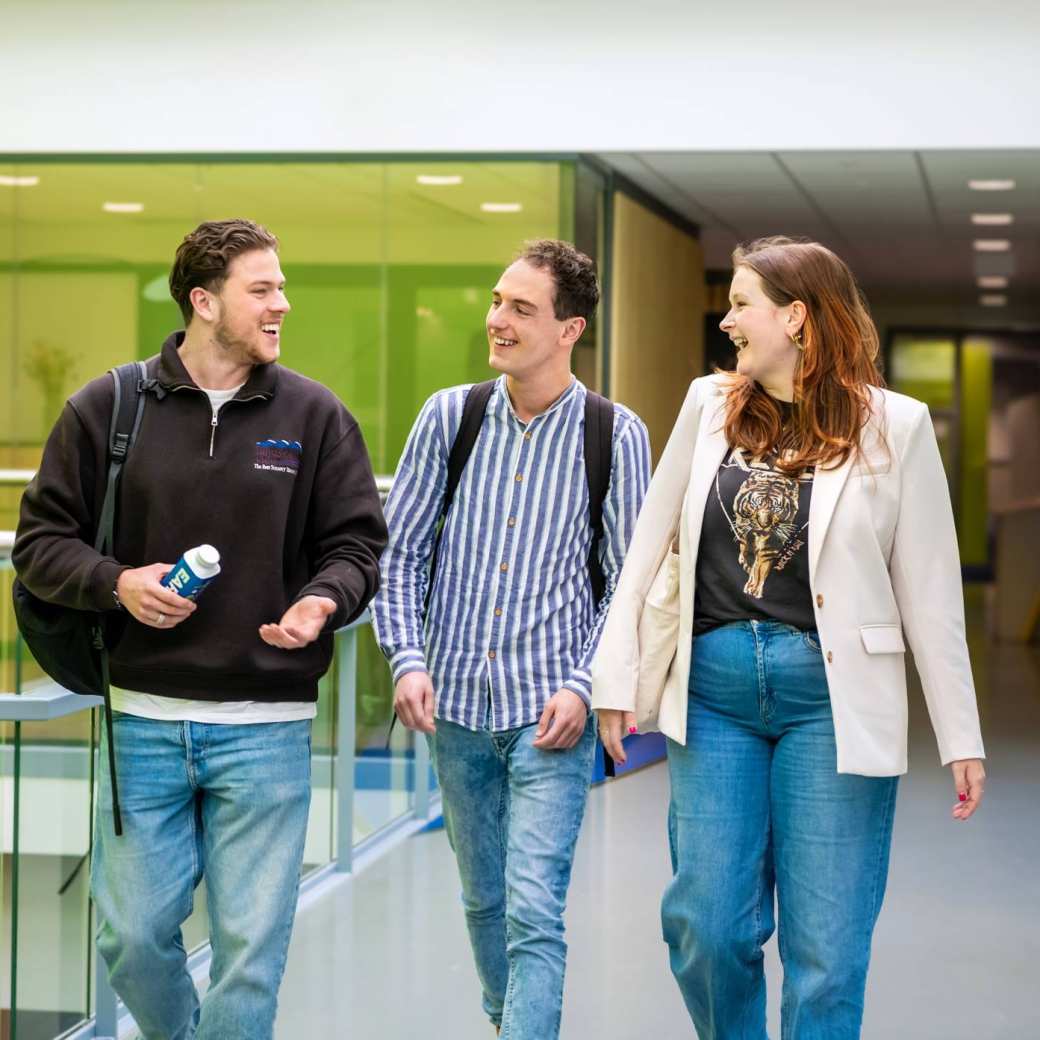 Studenten op de HAN wandelen samen en spreken elkaar