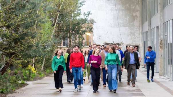 Groep studenten en docenten wandelt door IPKW met groen op de achtergrond. Fotografie Master Circulaire Economie voltijd.