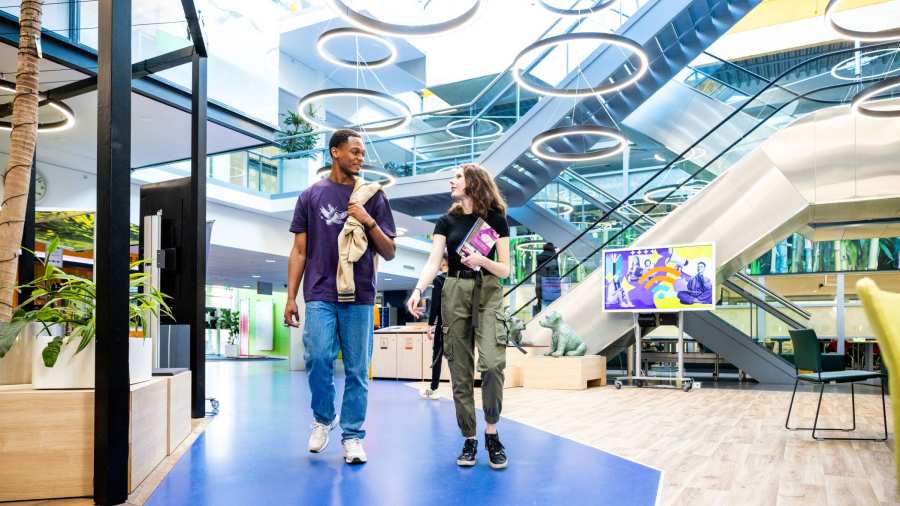 Studenten Learning and Development in Organisations (Opleidingskunde) lopen in de gang door het gebouw in Nijmegen