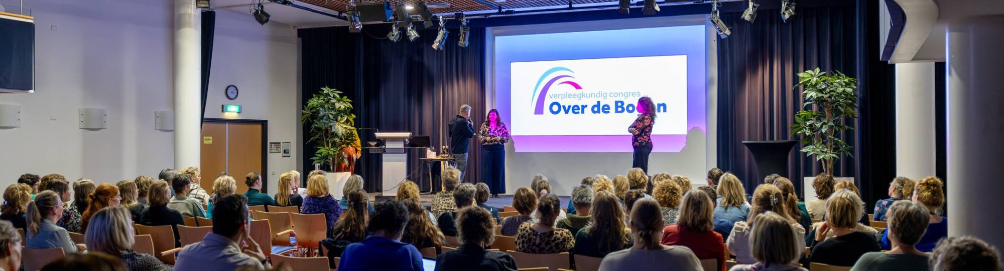 Congreszaal met bezoekers van Over de Bogen