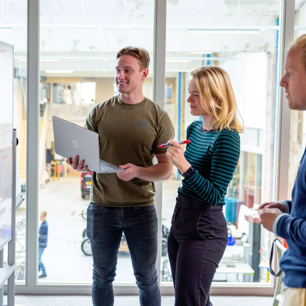 Studenten zijn aan het samenwerken en overleggen in een van de projectruimtes bij HAN Connectr op het IPKW