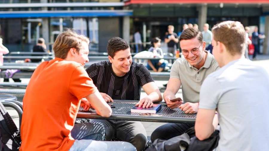 Logistics Management voltijd, foto 8383, studenten buiten aan tafel op het plein in Arnhem