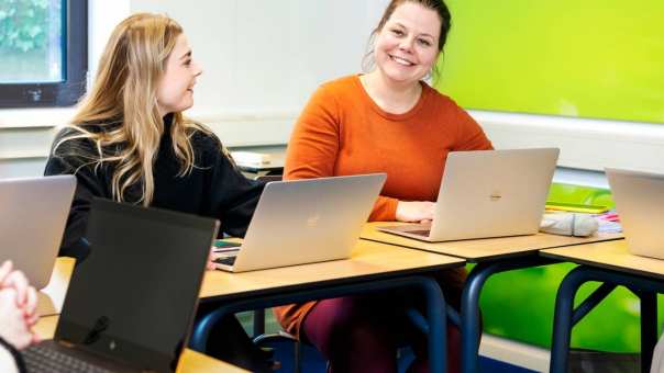 Twee cursisten aan het werk achter een laptop