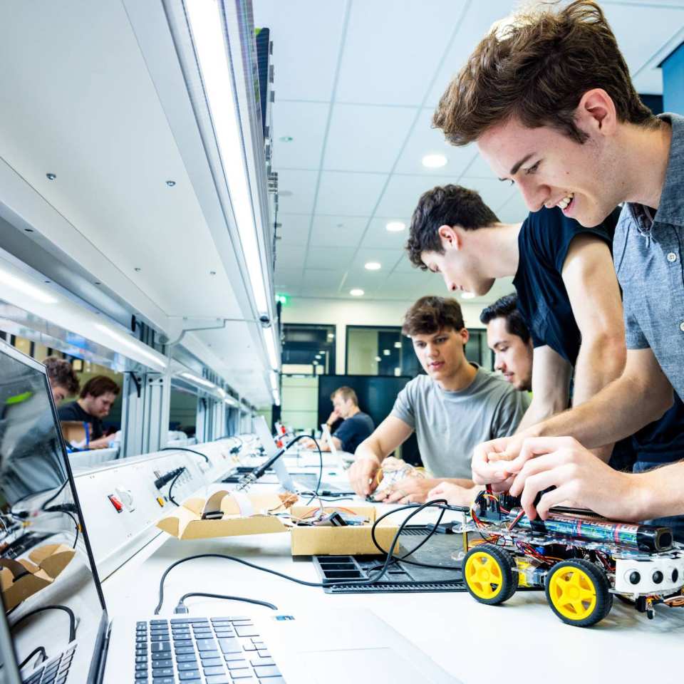 Student Marlo van embedded systems engineering werkt aan een programmeerbare auto in het lab.