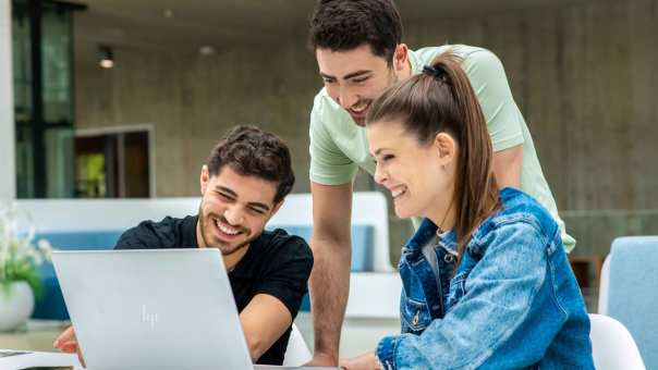 drie toekomstige studenten achter laptop voltooien aanmelding