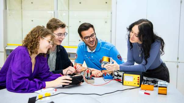 Vier studenten voeren een elektrisch circuit uit.
