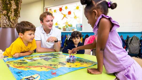 Drie kinderen spelen een bordspel in de klas. Foto van de opleiding leraar basisonderwijs 