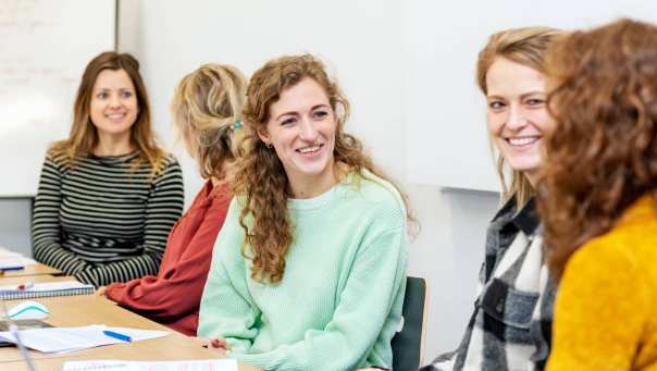 ALLEEN VOOR DE MANP | Lachende masterstudenten overleggen samen tijdens een klassikale les onderzoek op de HAN in Nijmegen.