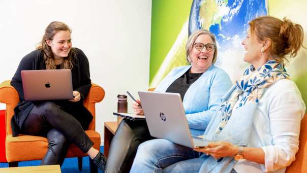 3 vrouwen in overleg op een oranje bank