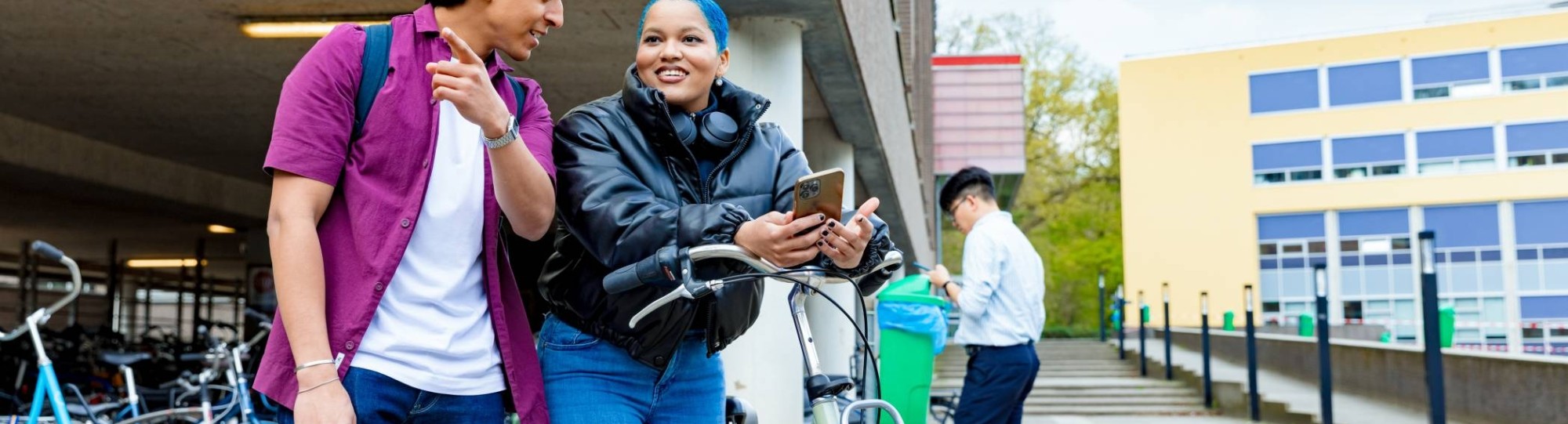 International students Diego and Chadionne with their bikes looking for directions on the Arnhem campus of HAN University of Applied Sciences.