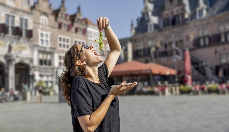 Een vrouw eet een krekel alsof het een haring is