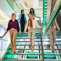 Studenten van Logistiek deeltijd wandelen door de gang en op de trap in hun pauze