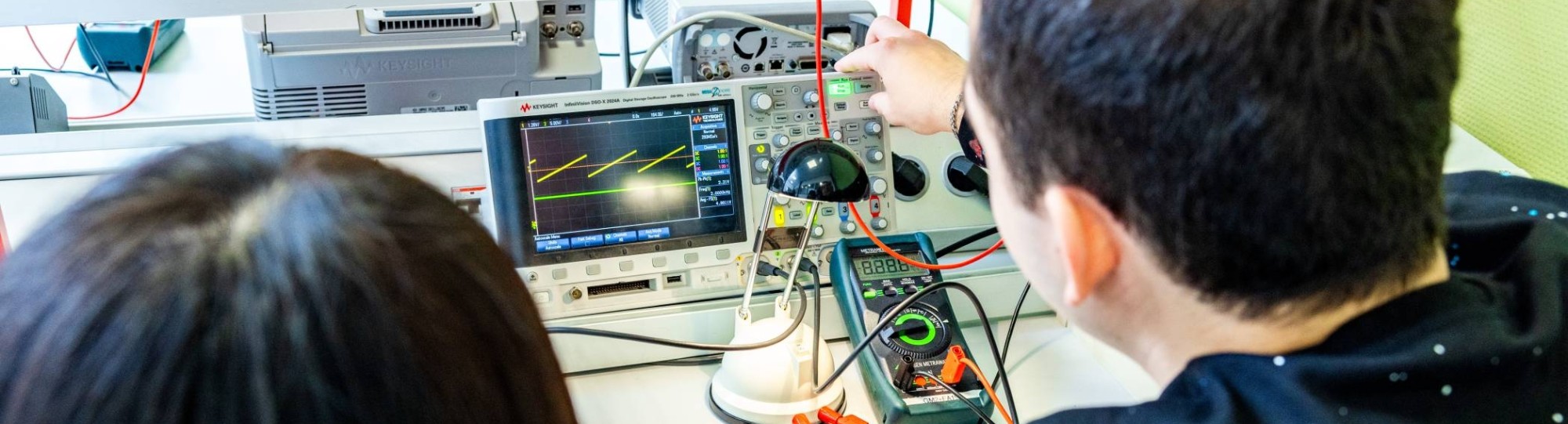 Twee studenten elektrotechniek doen een experiment met een zonnepaneel.