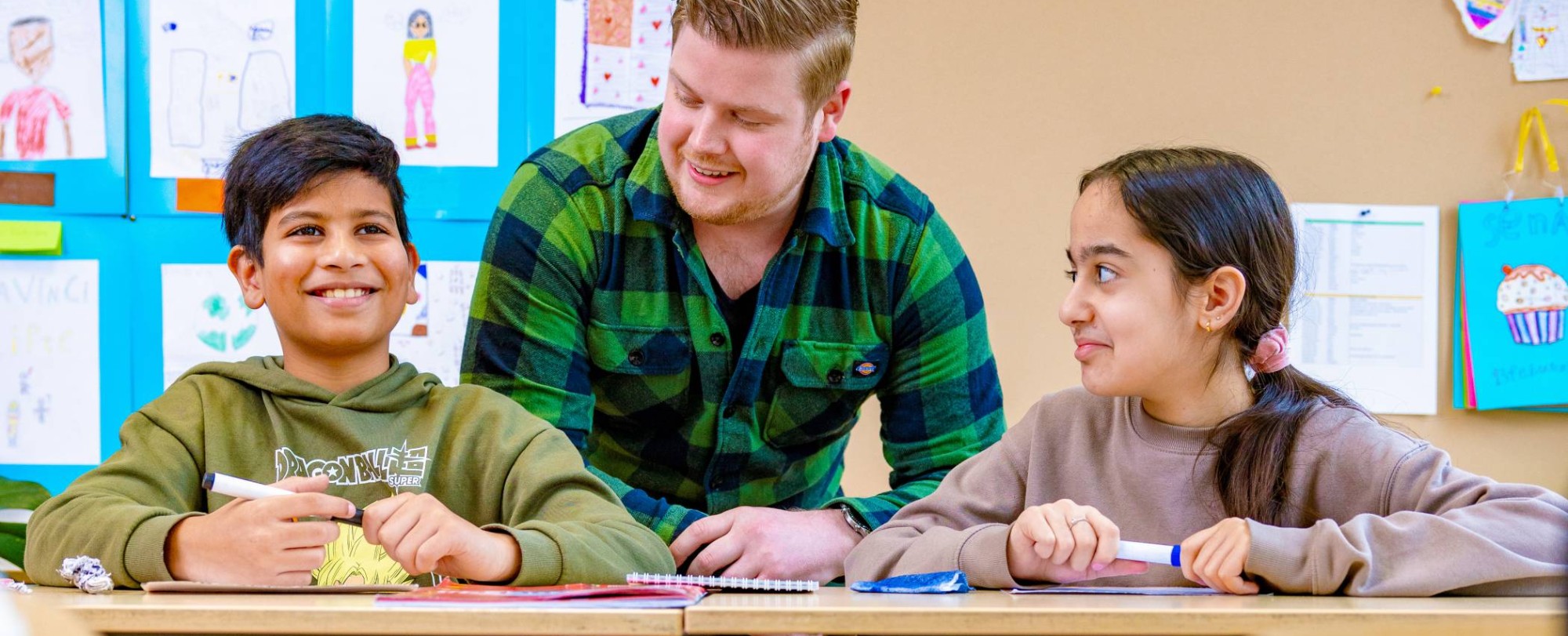 5 kinderen zitten in de klas en steken hun vinger op.