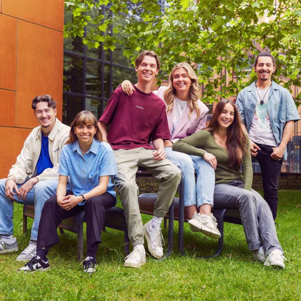 werving voltijd campagne, zes studenten zitten op en aan een picnictafel in de binnentuin