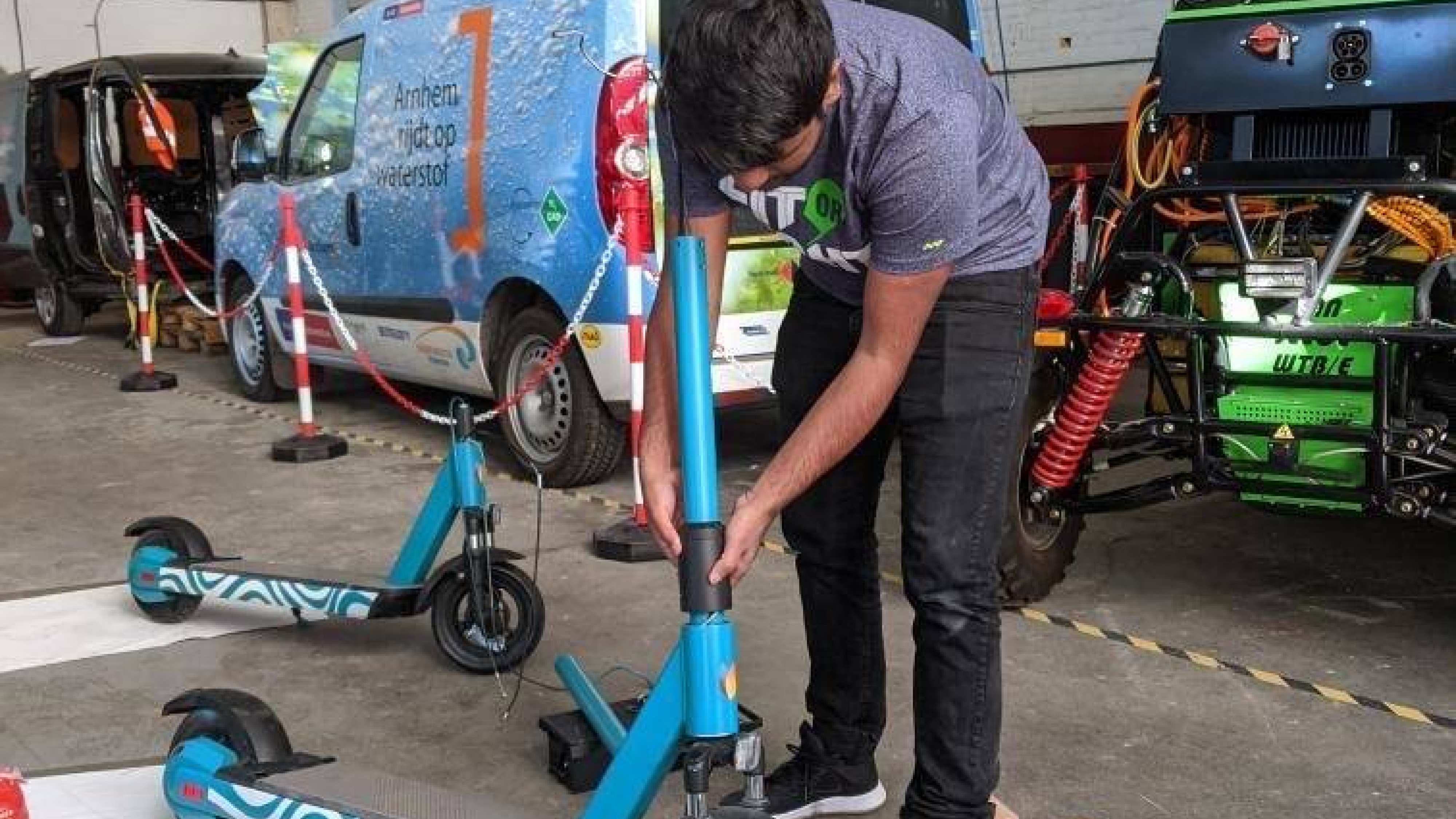 Student aan het werk in een werkplaats met een elektrische step