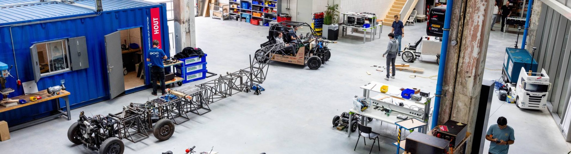 Overzichtsfoto van de grote hal, de grote ruimte, Mobility lab, van HAN Connectr op het IPKW.
In de hal zie je de waterstof bakfiets en de H2-demonstrator, ook zie je het voertuig MORE. Automotive Research