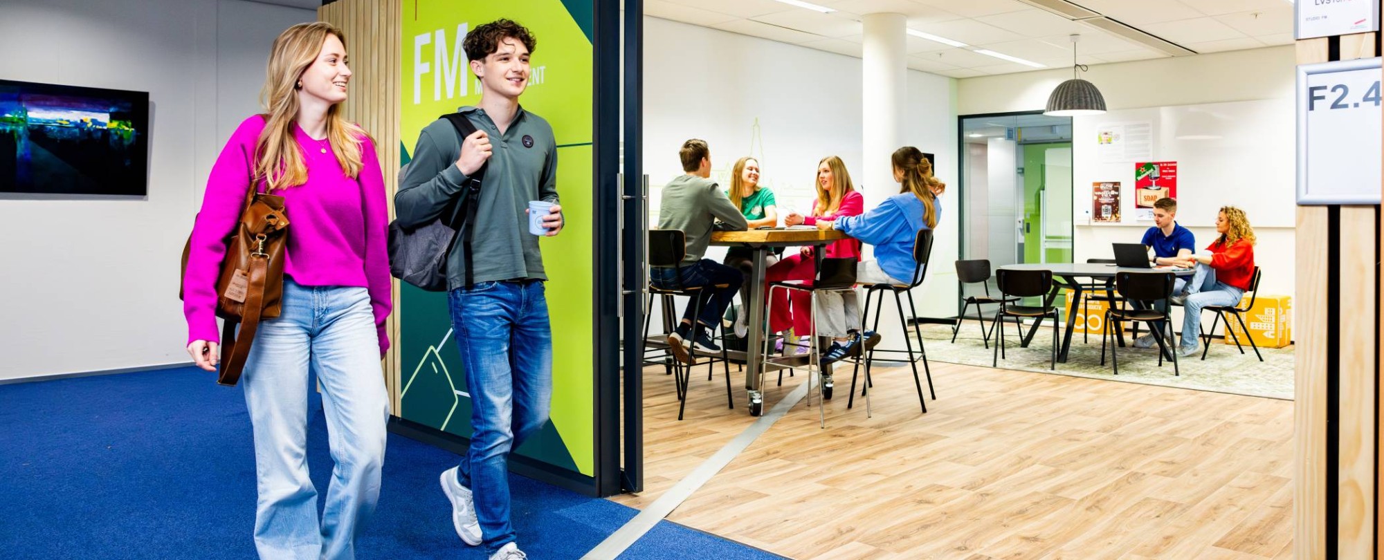 Studenten Facility Management lopen voor de studio van de opleiding