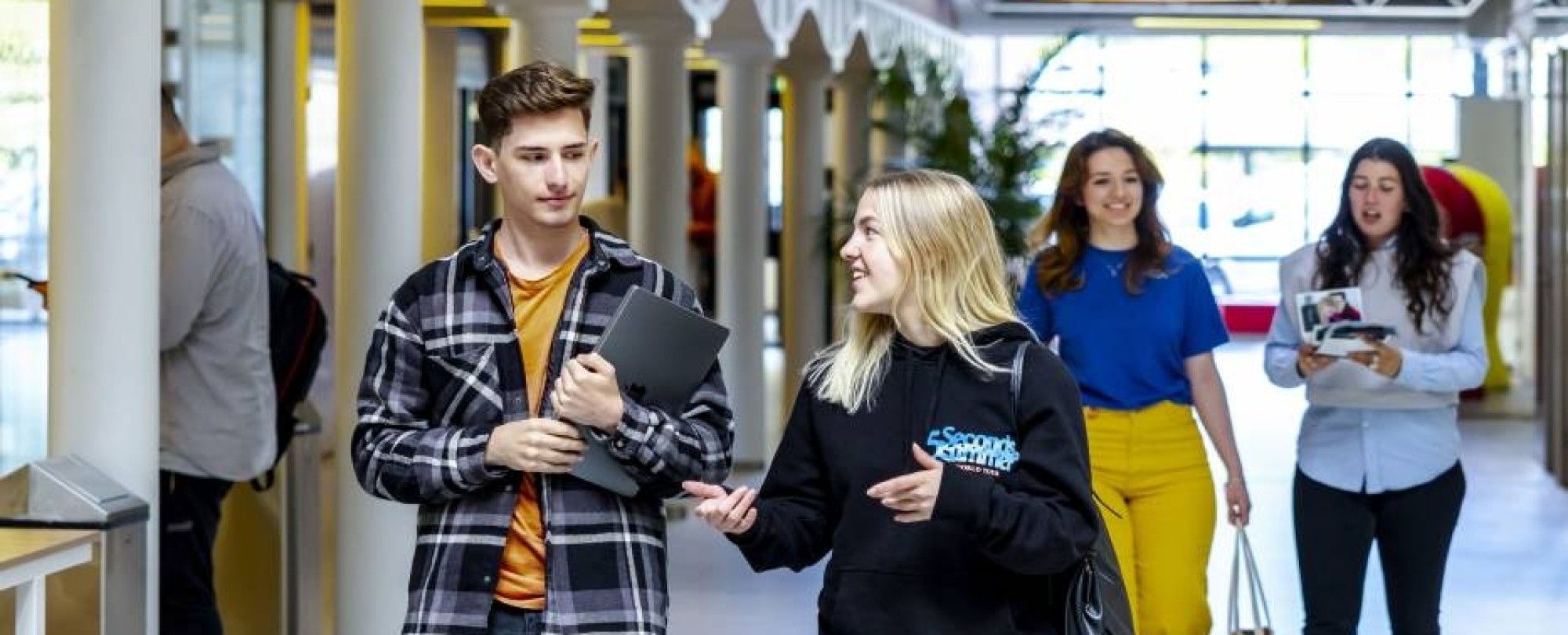 HAN studenten van de Engelstalige Communication opleiding lopen door een gang